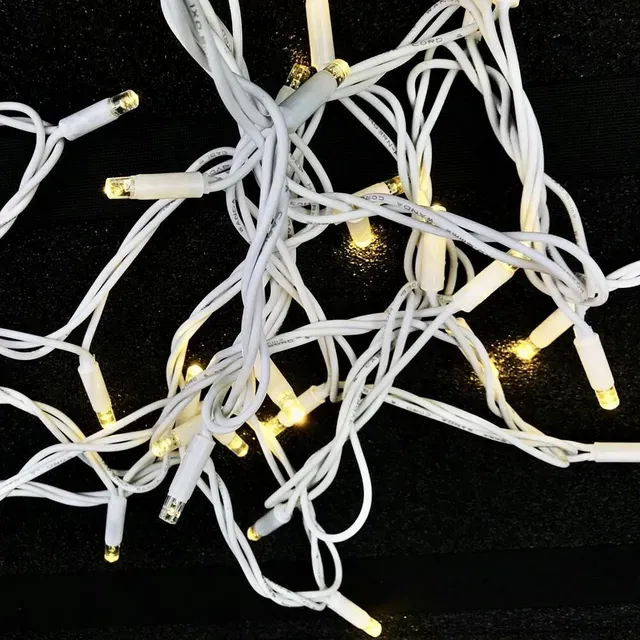 A bunch of white christmas lights on a black background