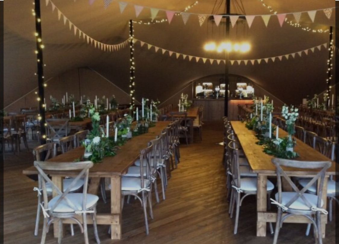 A large tent with tables and chairs inside of it