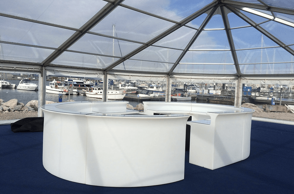 A clear tent with a circular table inside of it