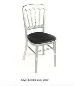 A silver spindle back chair with a black cushion.