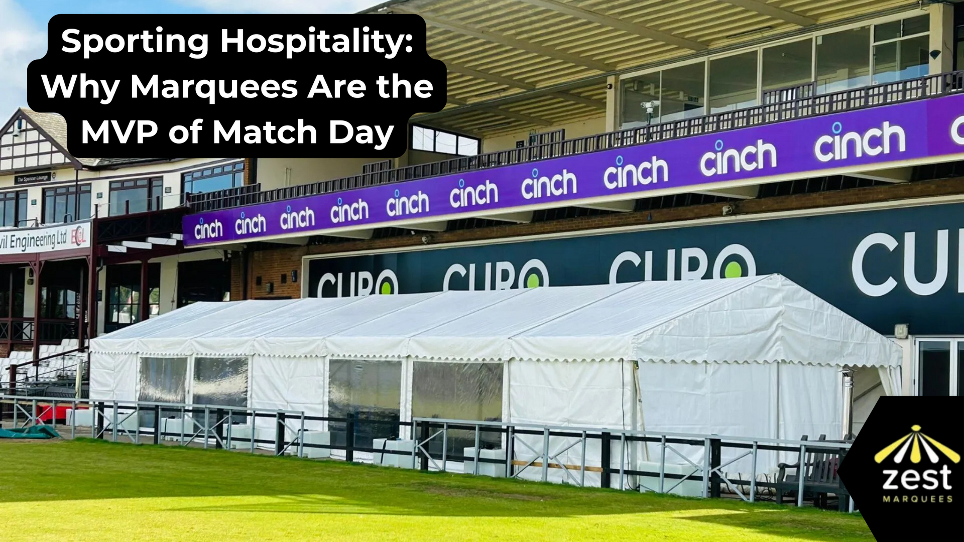 White marquee in front of a cricket stadium with 