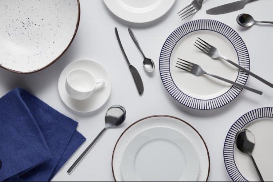 A table with plates , silverware and a blue napkin