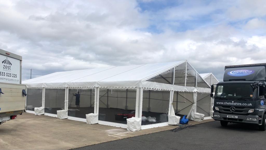 A truck is parked in front of a large white tent.