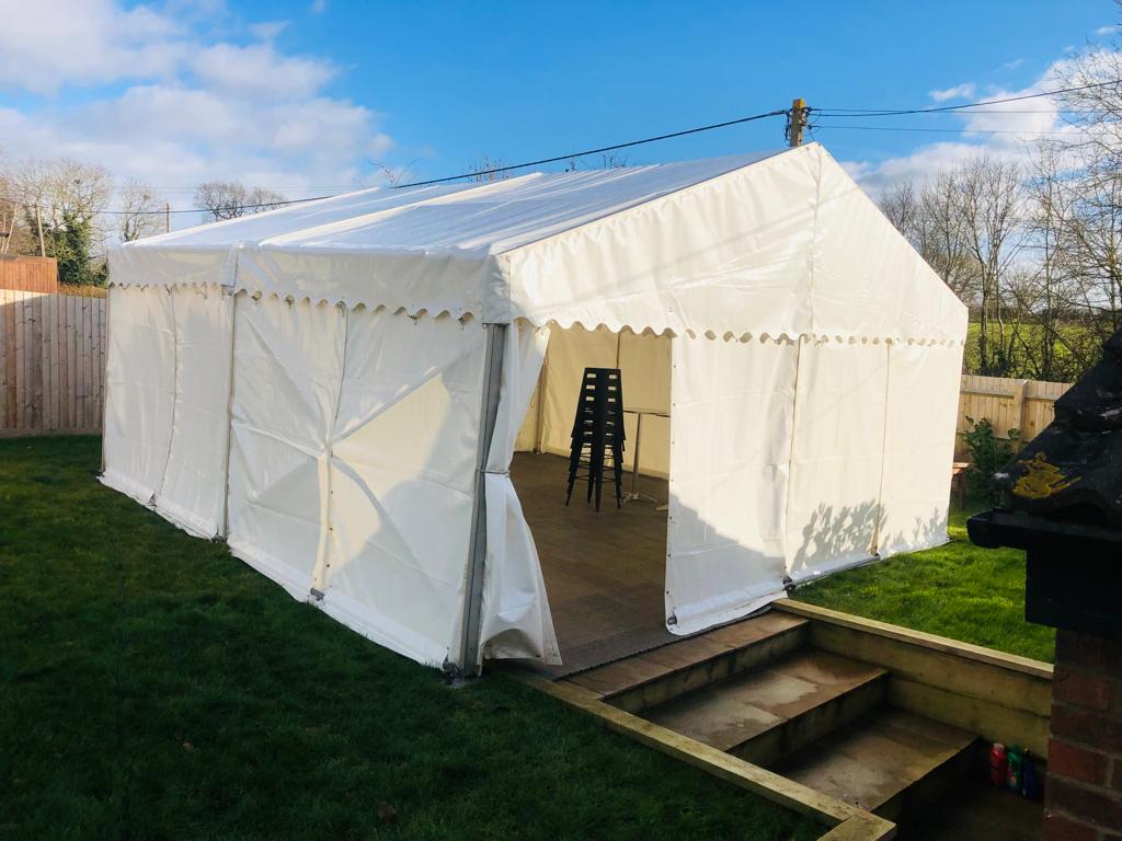 A large white tent is sitting on top of a lush green field.