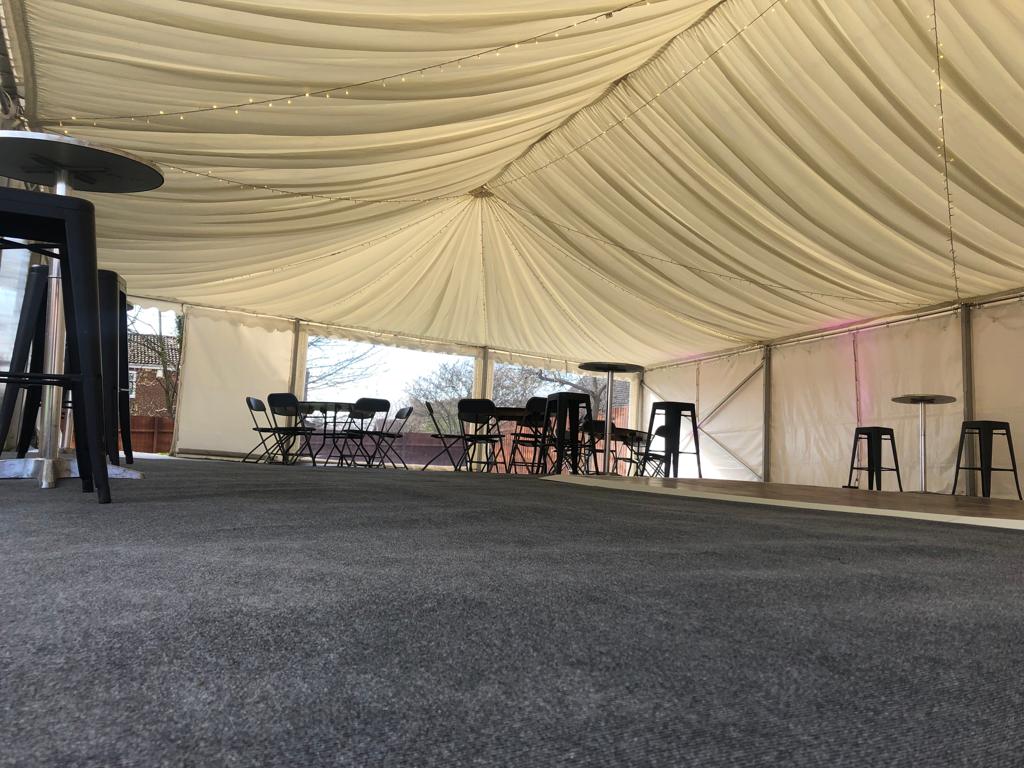 A large tent with tables and chairs inside of it.