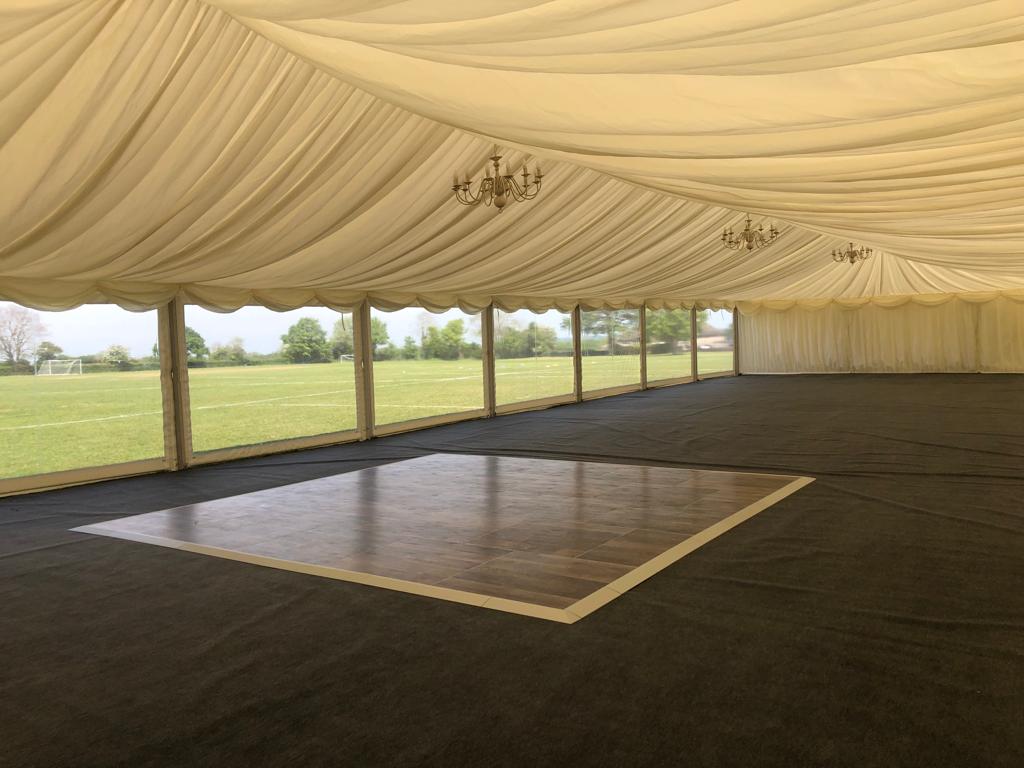 There is a dance floor in the middle of the tent.