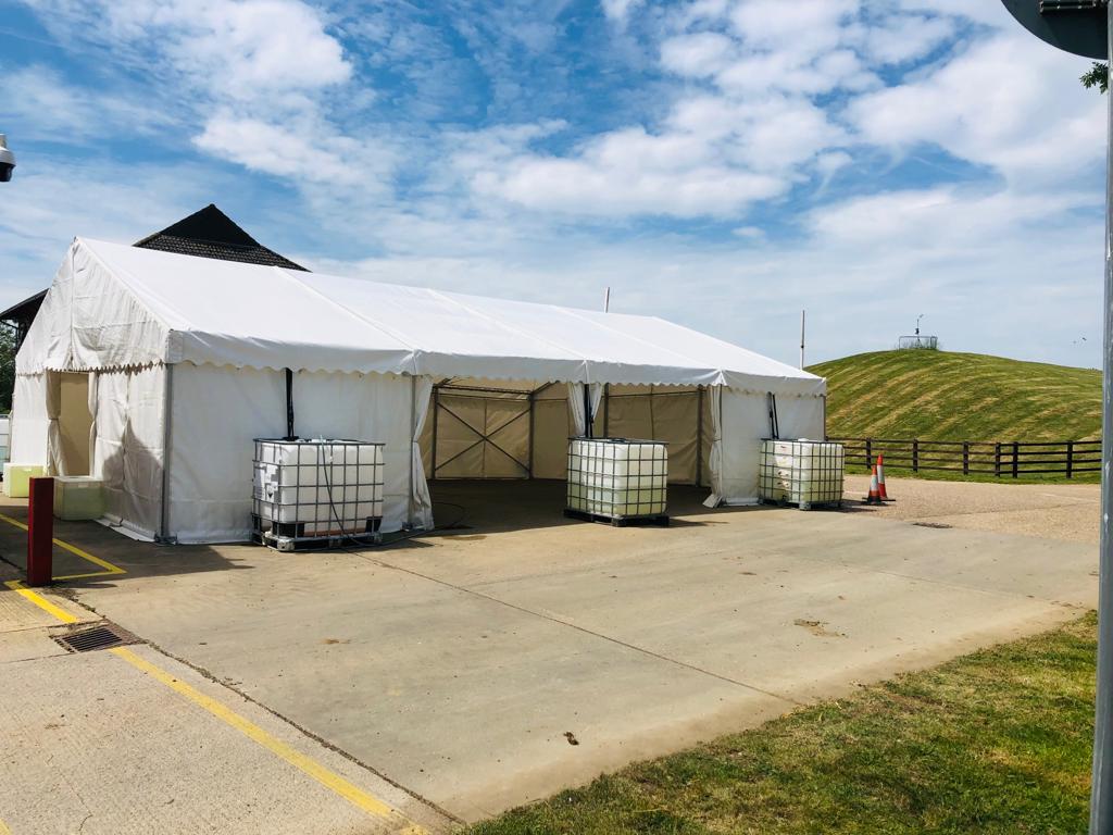 A large white tent is sitting in the middle of a parking lot.