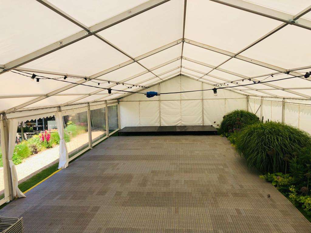 A large white tent with a stage inside of it.