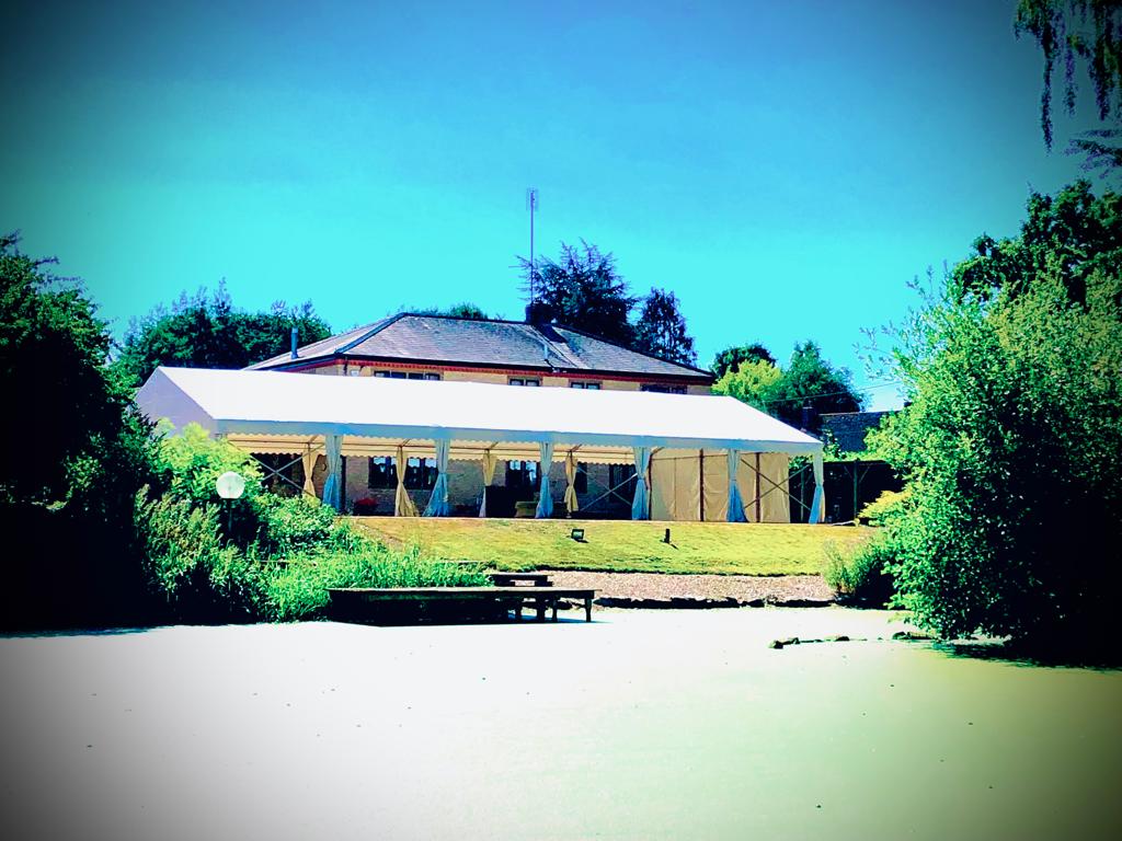 A large white tent is sitting in front of a house
