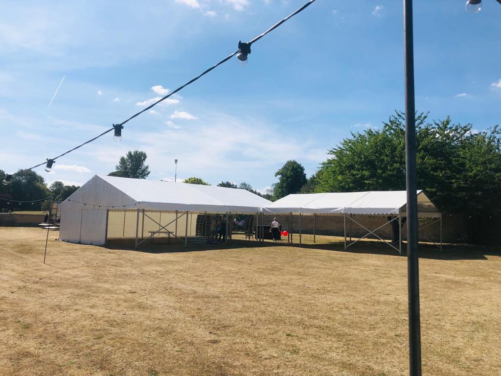 A large white tent is sitting in the middle of a field.