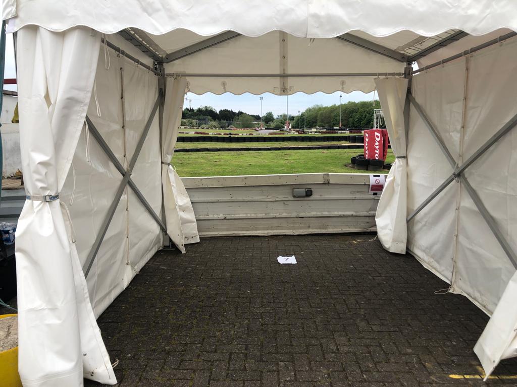 A white tent is sitting on a brick floor.