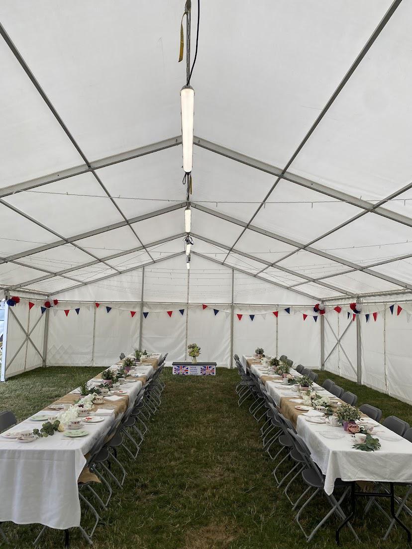 A large tent with tables and chairs inside of it.