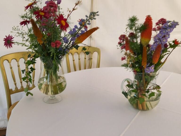 Two vases filled with flowers are on a table.