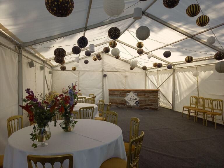 A table with a vase of flowers on it in a tent