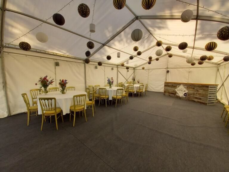 A large room with tables and chairs under a tent