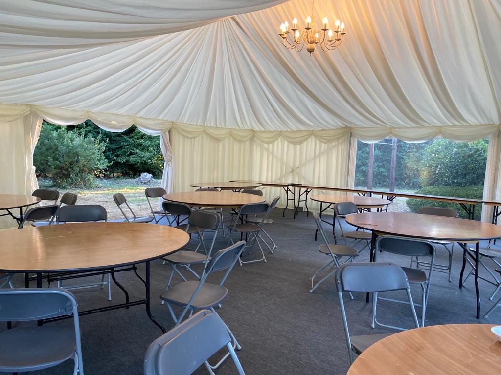 A large tent with tables and chairs inside of it.