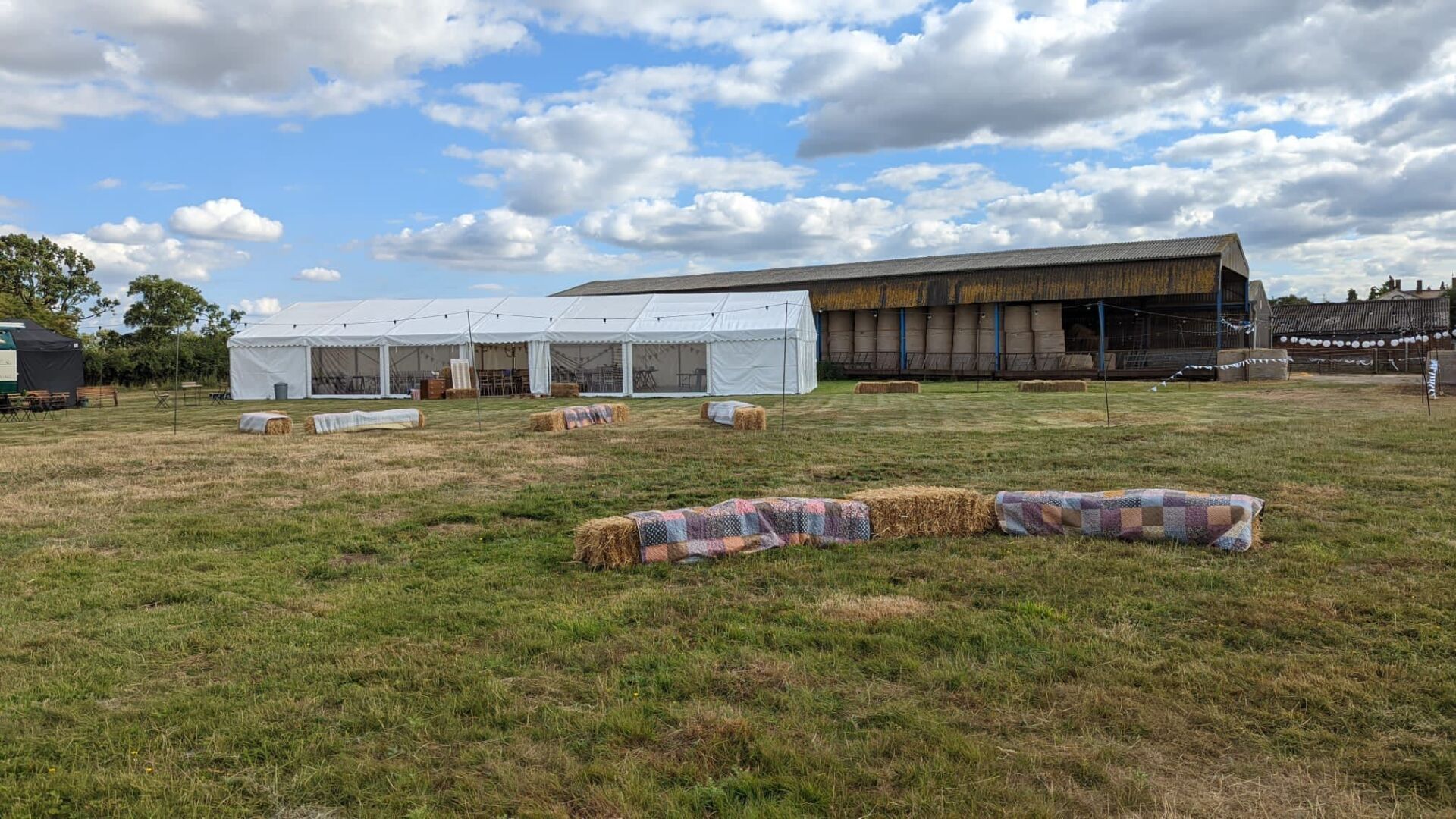 A large white tent is sitting in the middle of a grassy field.