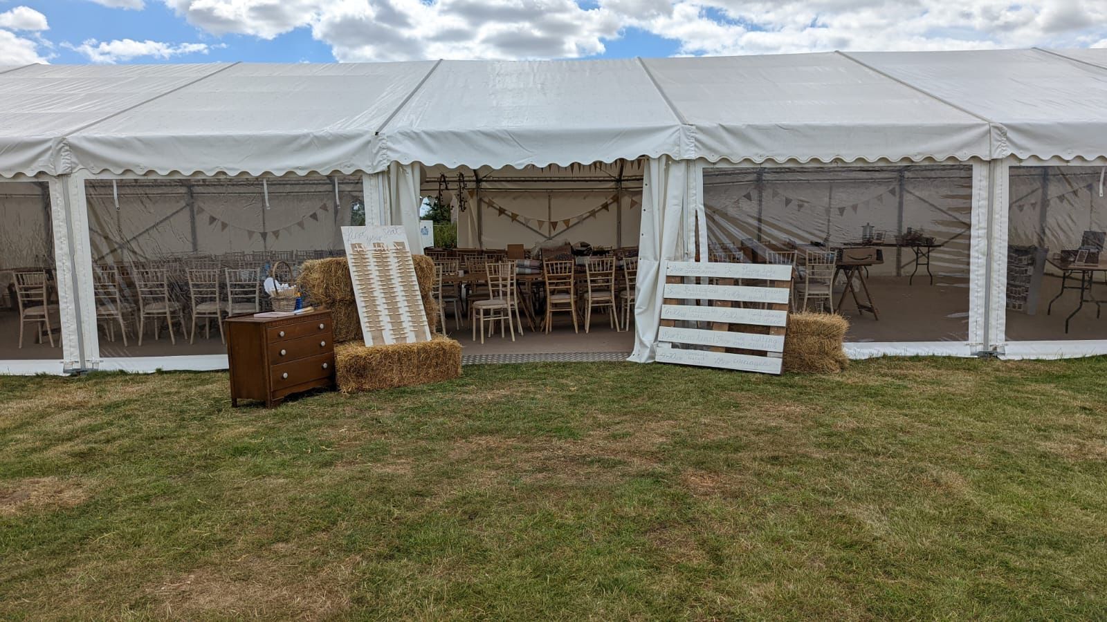 A large white tent is sitting in the middle of a grassy field.