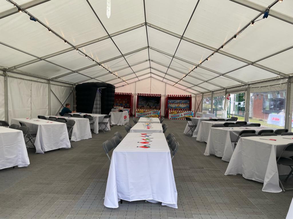 A large tent with tables and chairs inside of it.