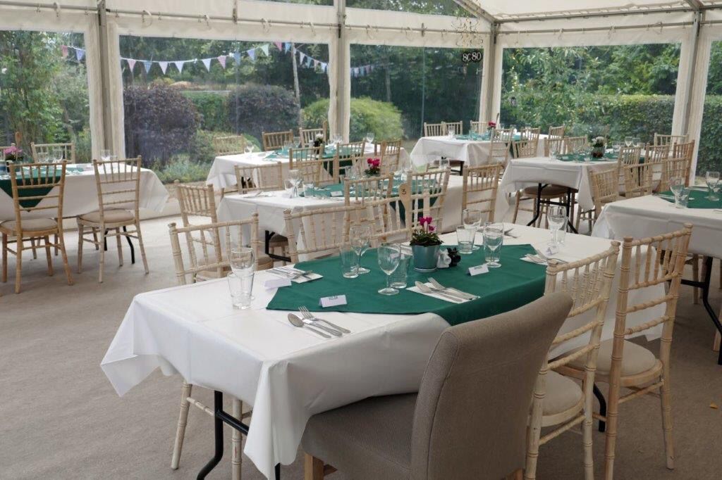 A large tent with tables and chairs set up for a party.