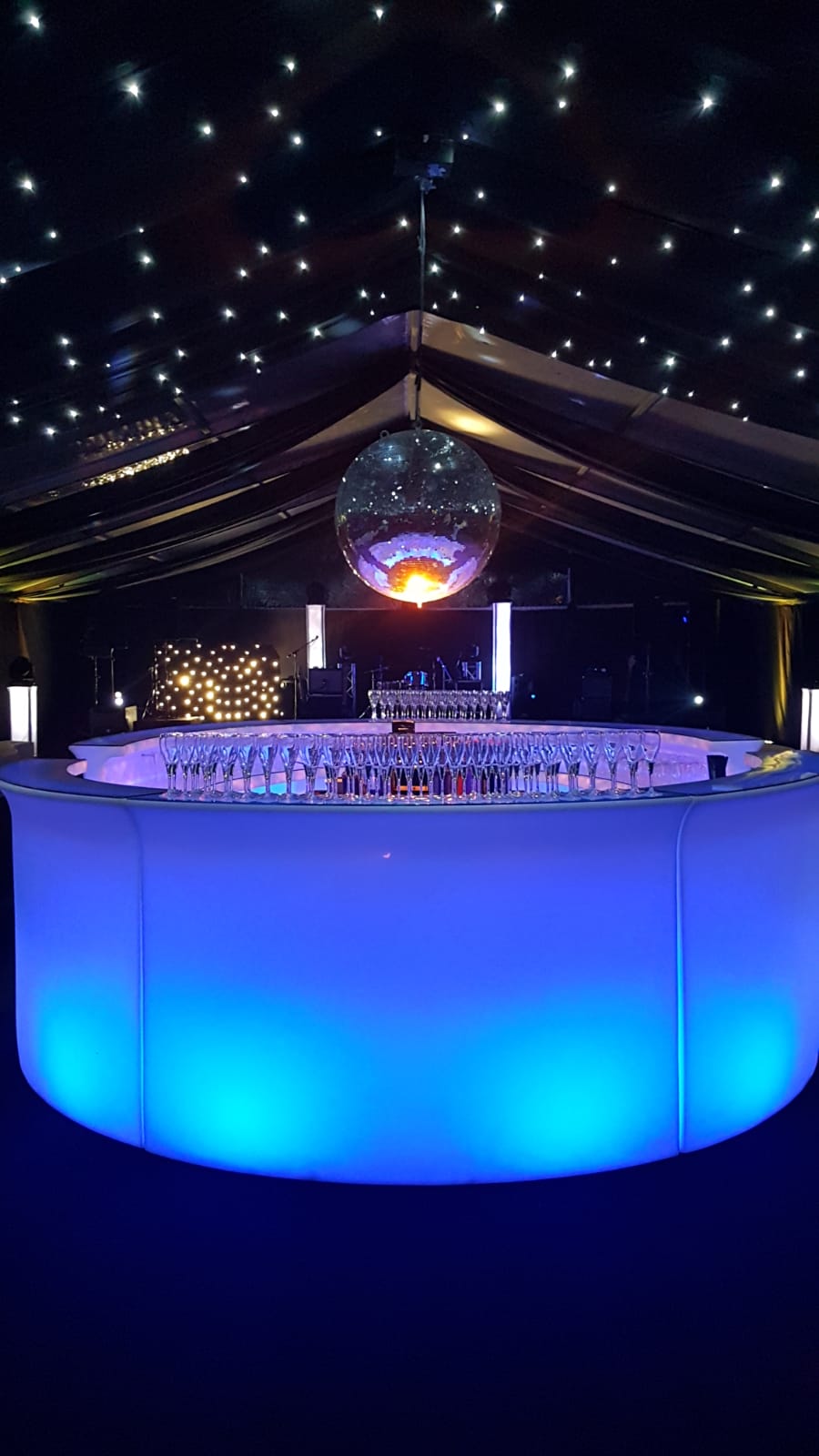 A disco ball is hanging from the ceiling above a bar.
