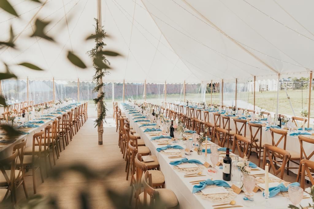 A long table set for a wedding reception in a tent.