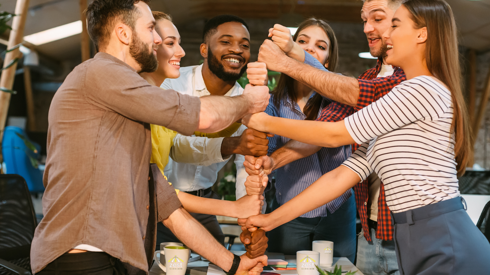 A group of people are putting their hands together in a circle.