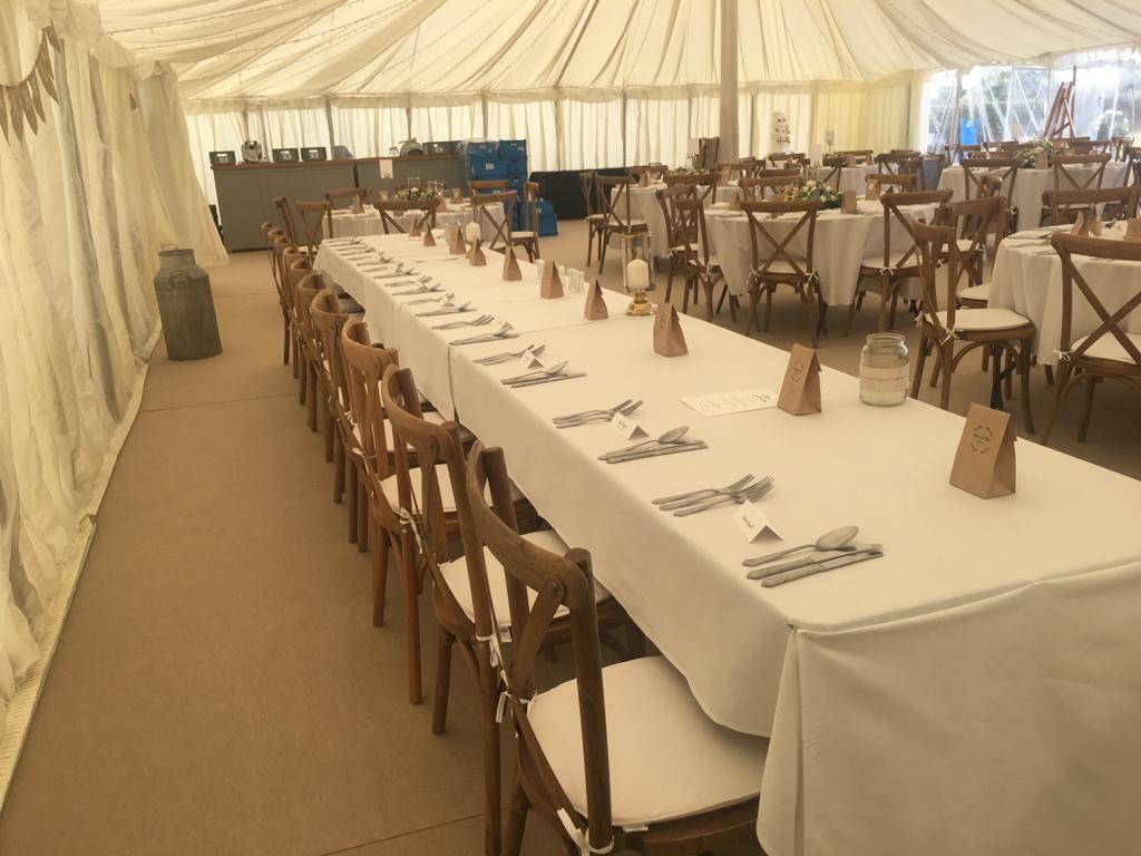 A long table with utensils on it in a tent.