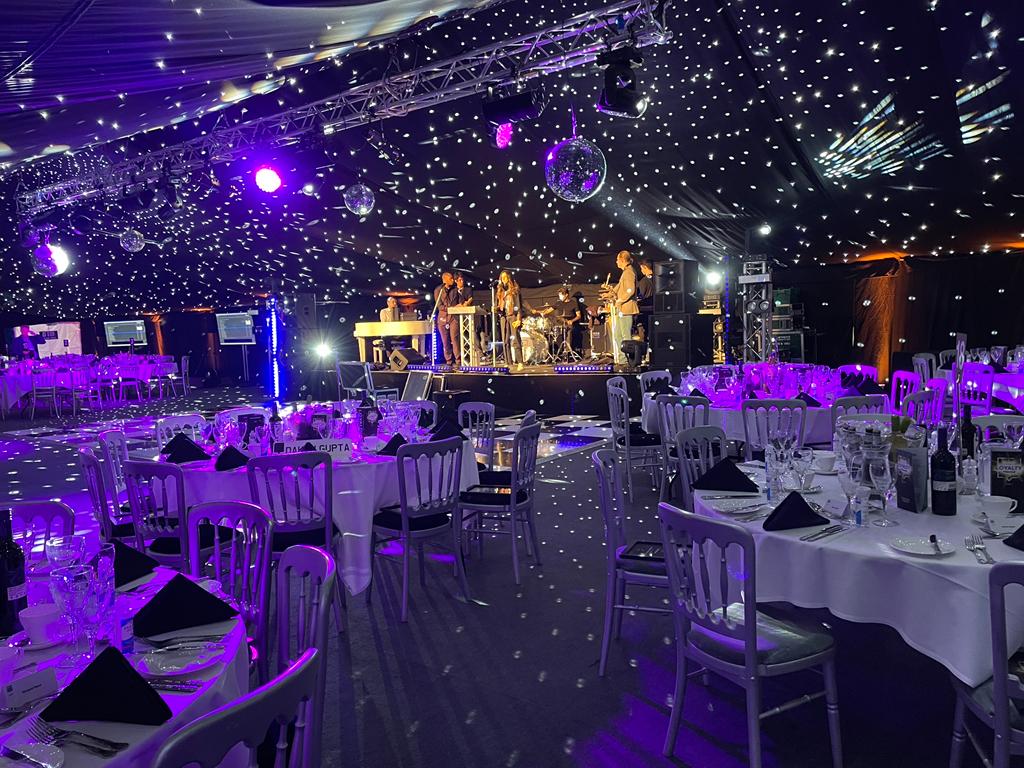 A large room filled with tables and chairs and a disco ball.