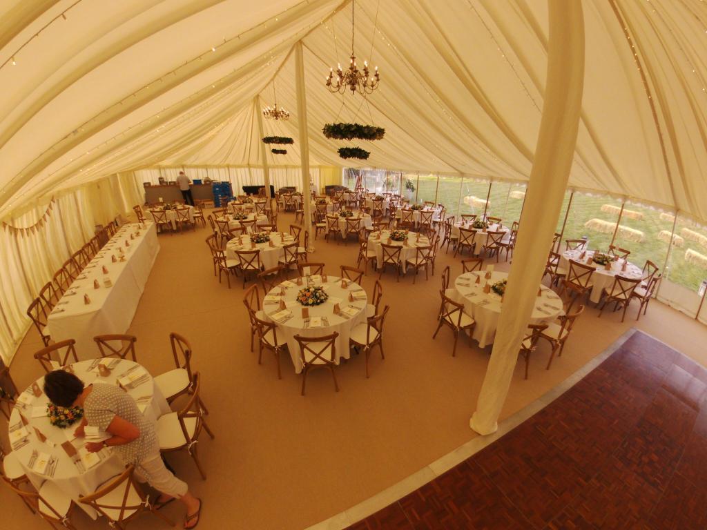 An aerial view of a large tent filled with tables and chairs