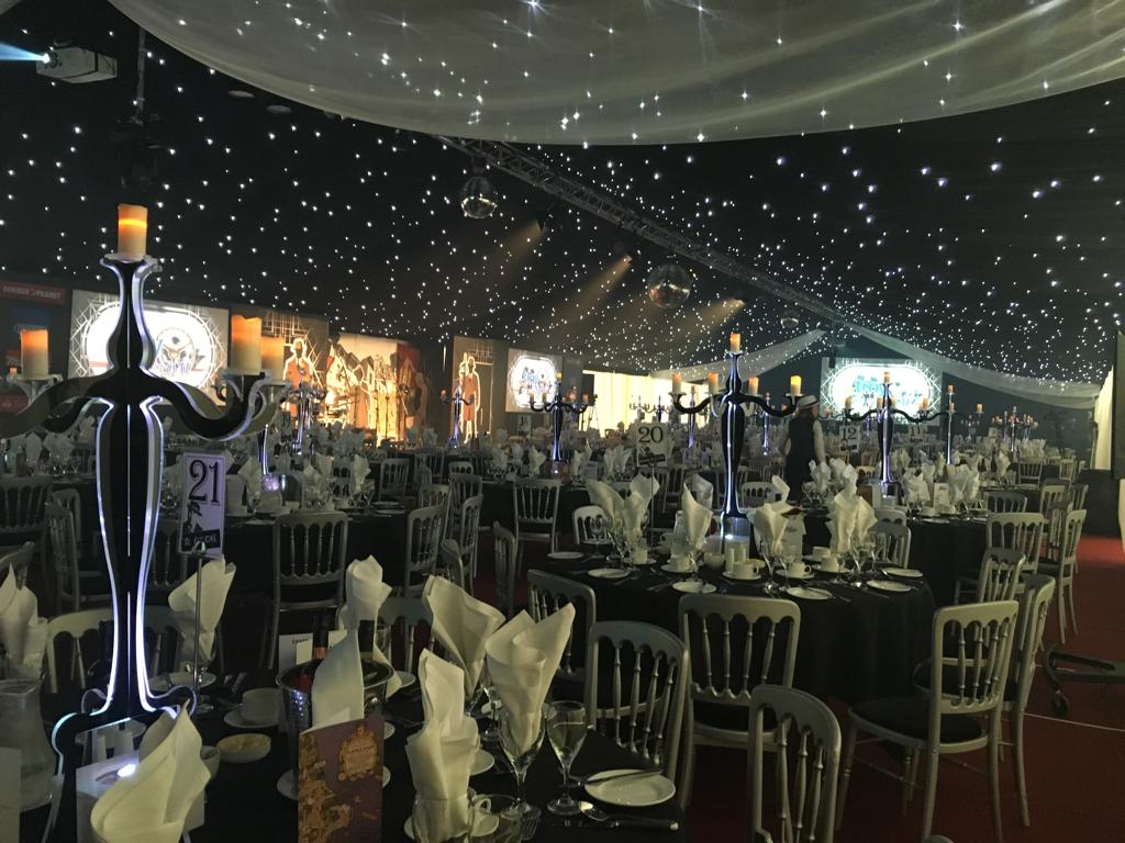A large room with tables and chairs set up for a party.