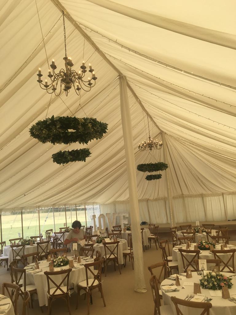 A large tent filled with tables and chairs and a chandelier.