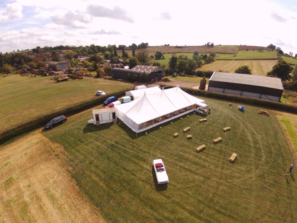 An aerial view of a large tent in a field.
