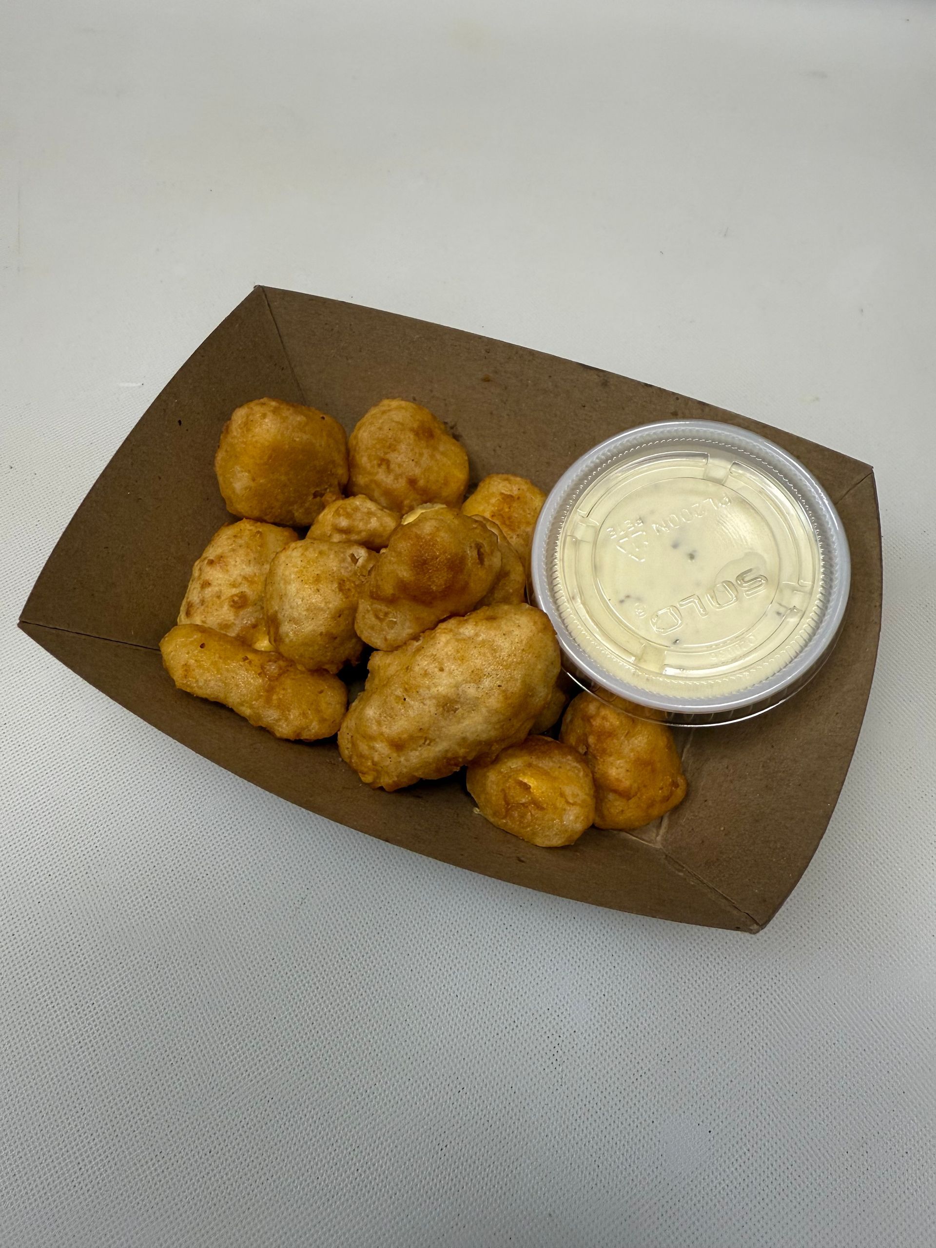 Fried food with dipping sauce in a cardboard tray.