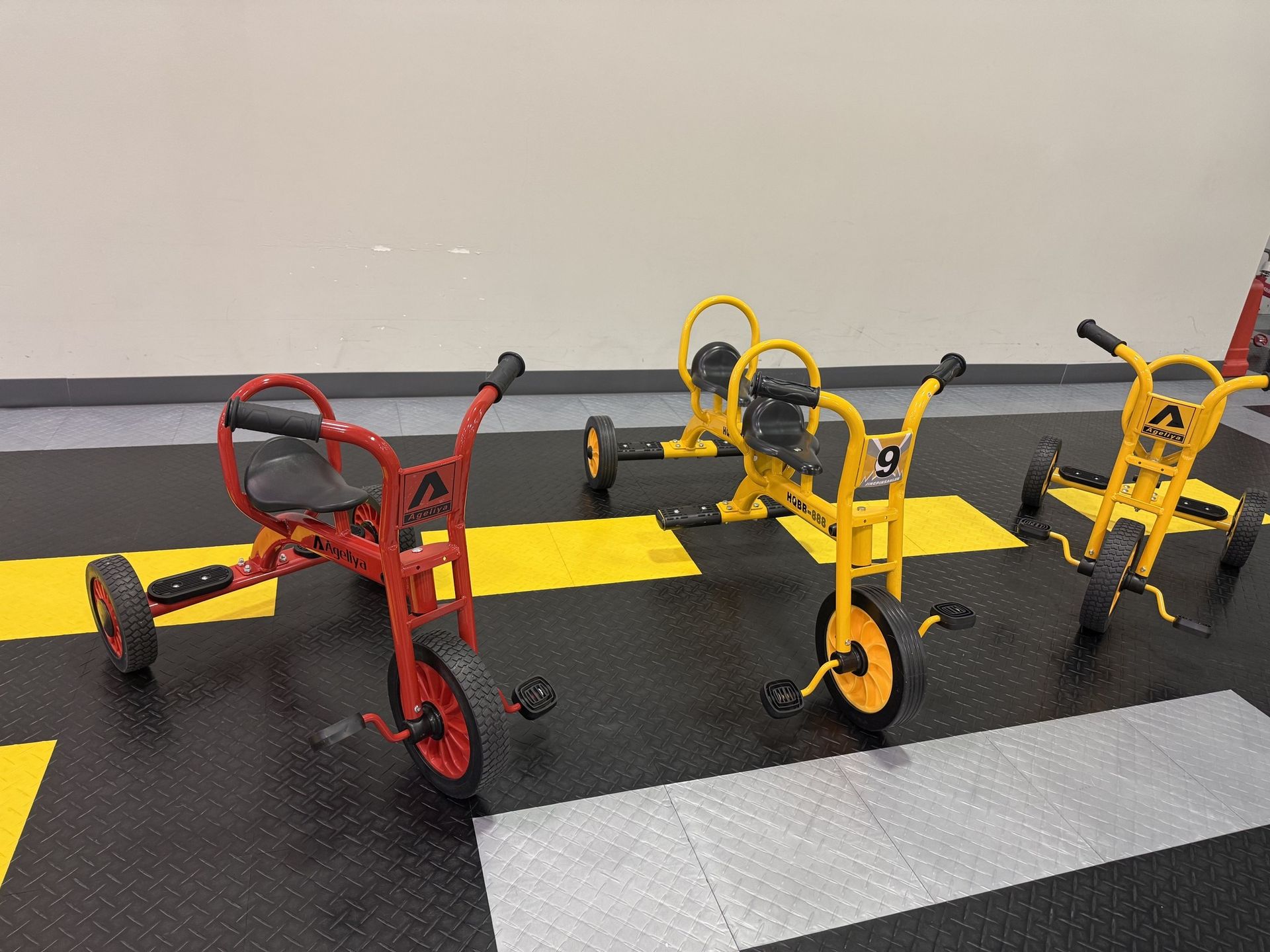 Two young girls playing shop with toy food. One is at a cash register, the other looking on.