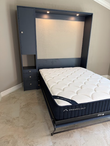 A dark blue Murphy bed in a room with light walls and tile flooring, featuring built-in shelving, drawers, and lighting.