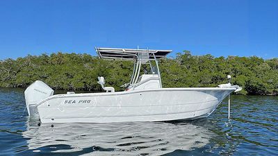 White Sea Pro boat on the water with mangrove trees in the background under a blue sky.