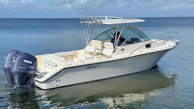 White motorboat with twin blue outboard motors on calm water.