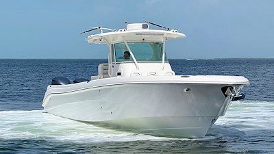 White motorboat on water, blue sky background.