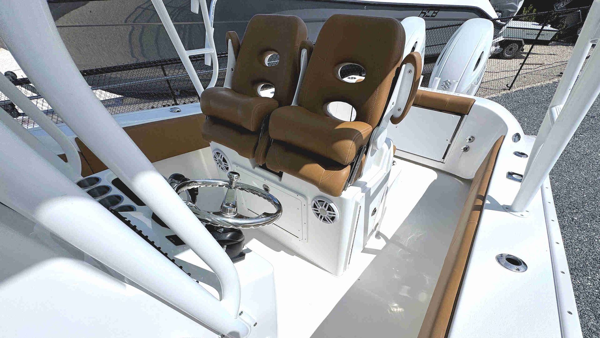 Swivel captains chairs beside a fishing rod holder and center console equipment