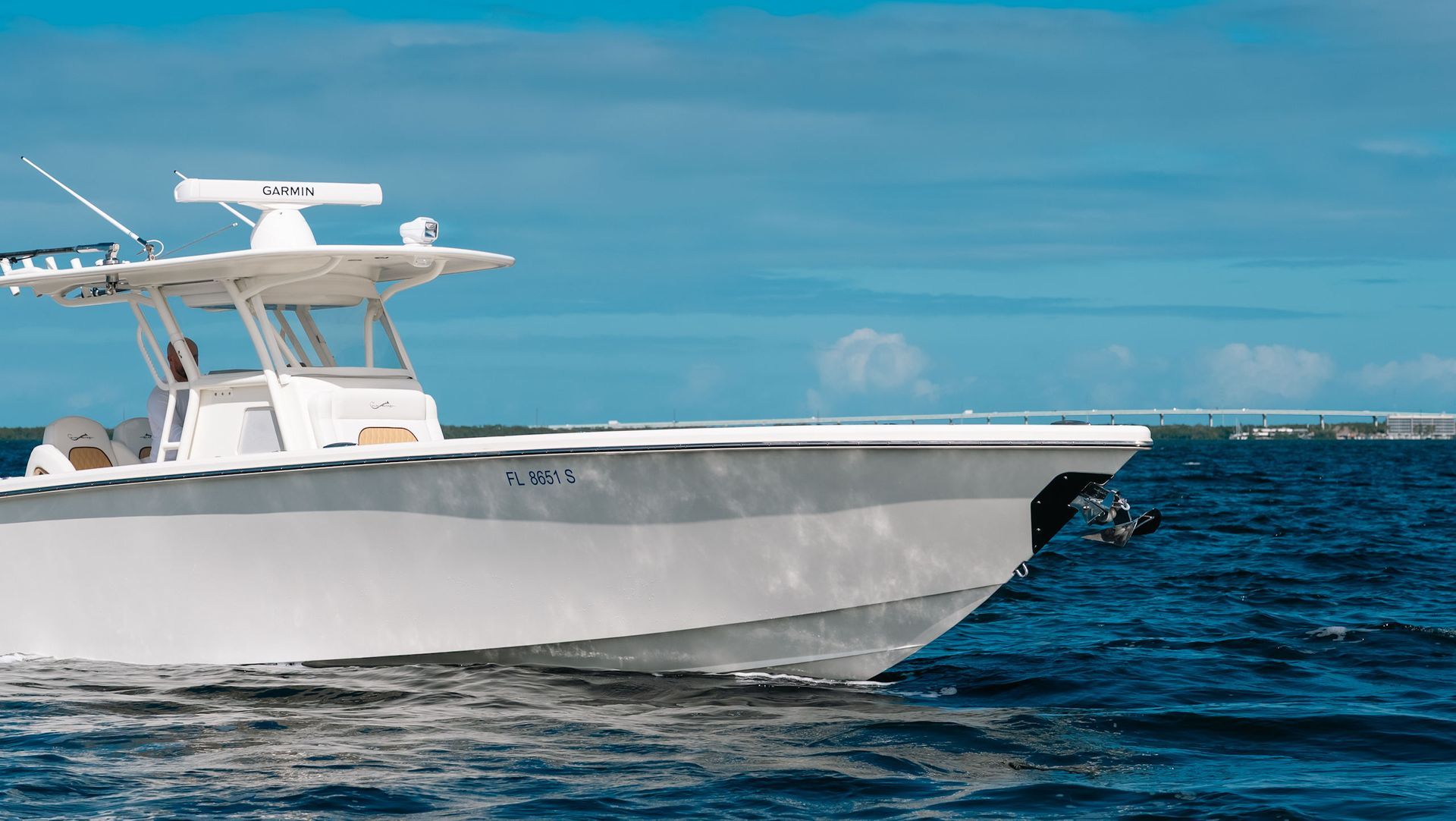 White motorboat cruising on blue ocean under a clear sky
