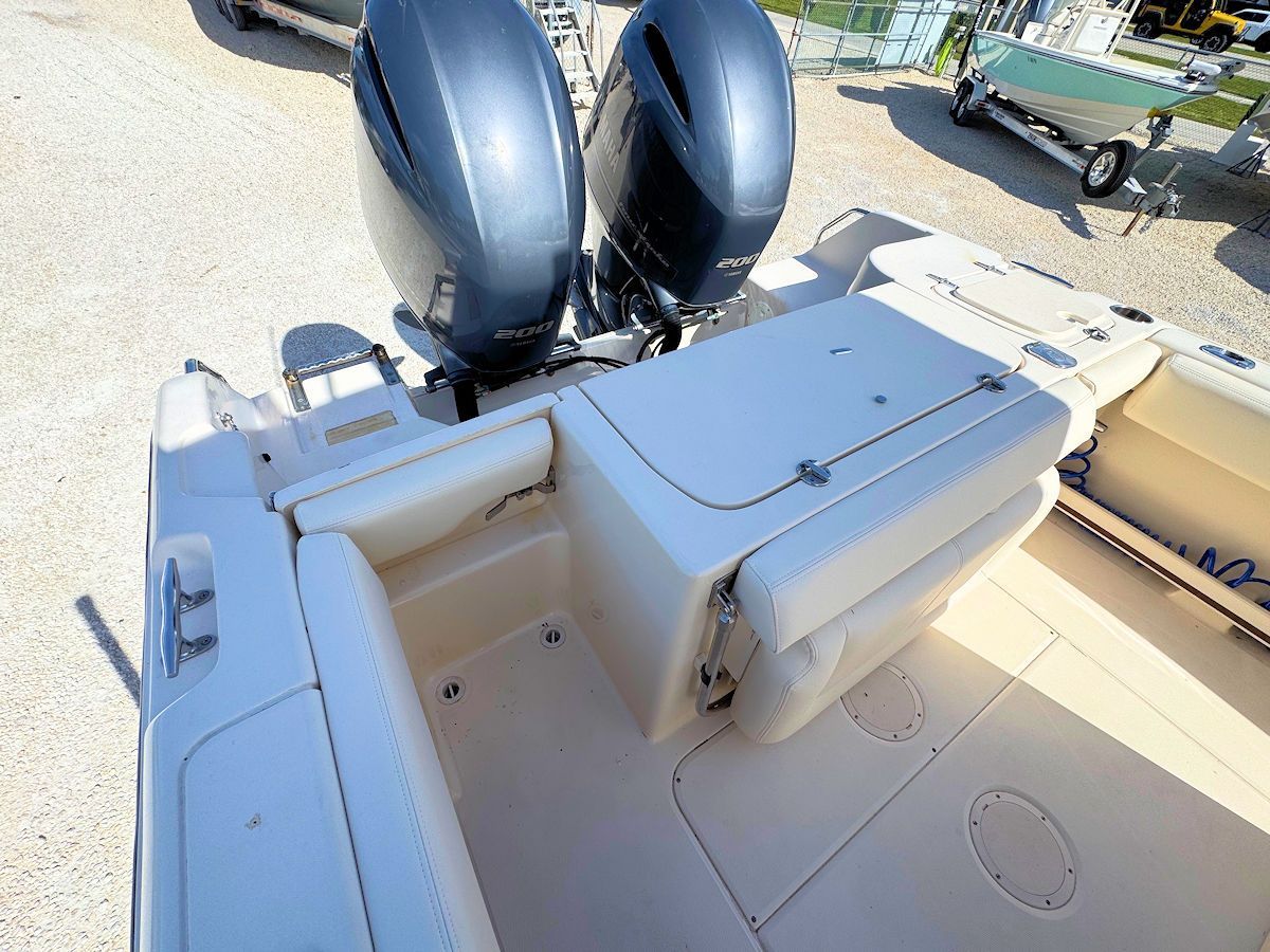 Boat stern with dual outboard motors and beige seating.
