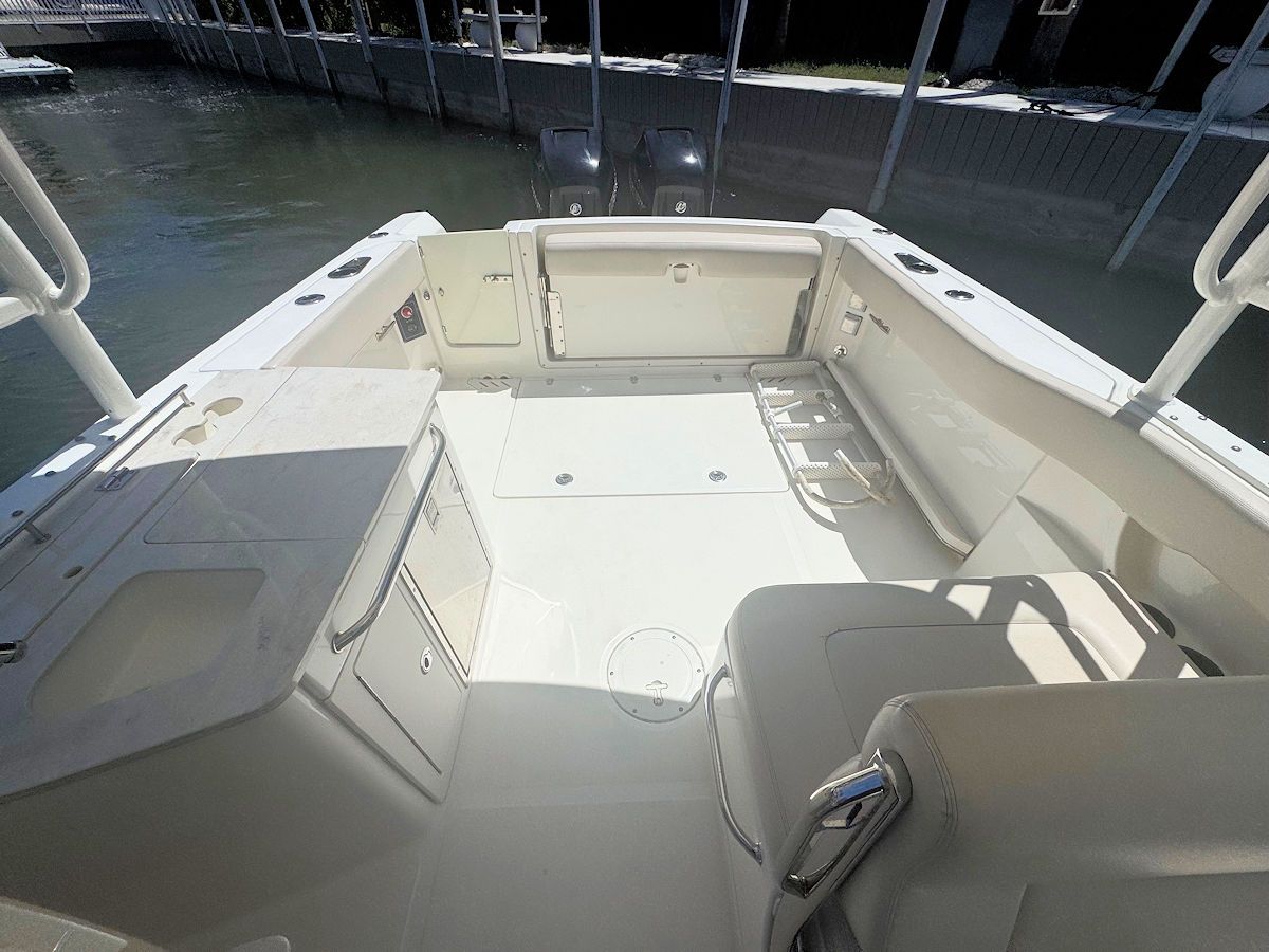 View from inside a light-colored boat, showing the deck, storage compartments, and railings.