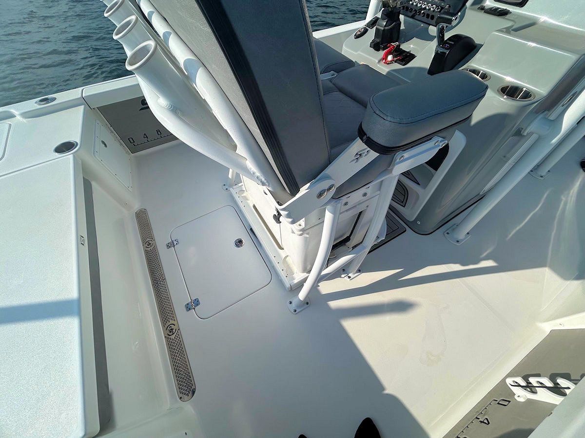Boat deck with a white seat and rod holders, angled view.