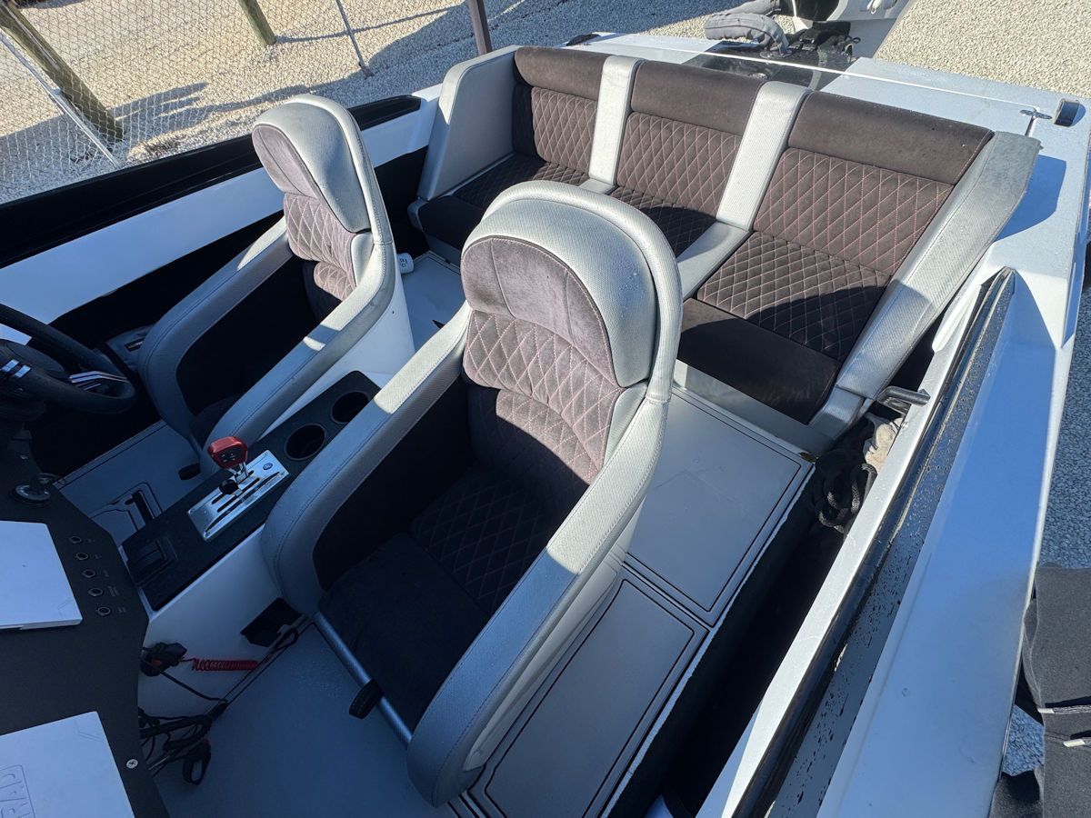 Interior view of a white and black speed boat with cushioned seating.