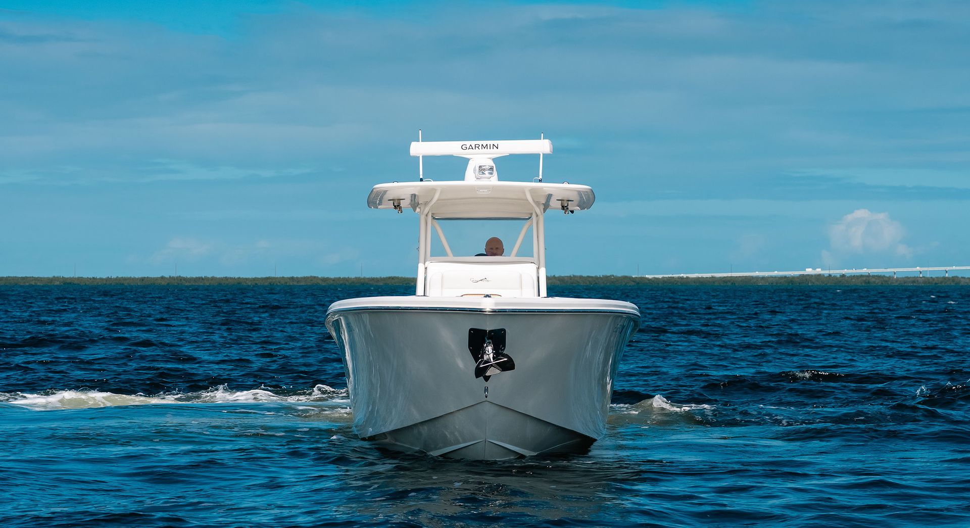 White motorboat cruising on blue ocean under a clear sky