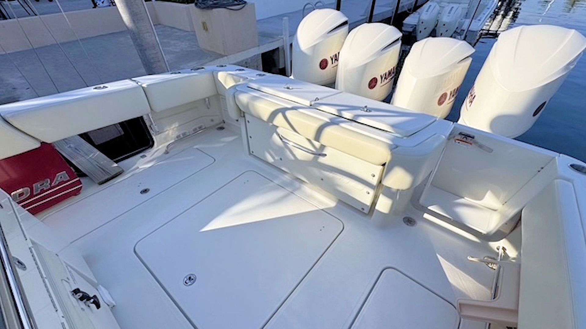White aftdeck with railings and four outboard motors in bright sunlight