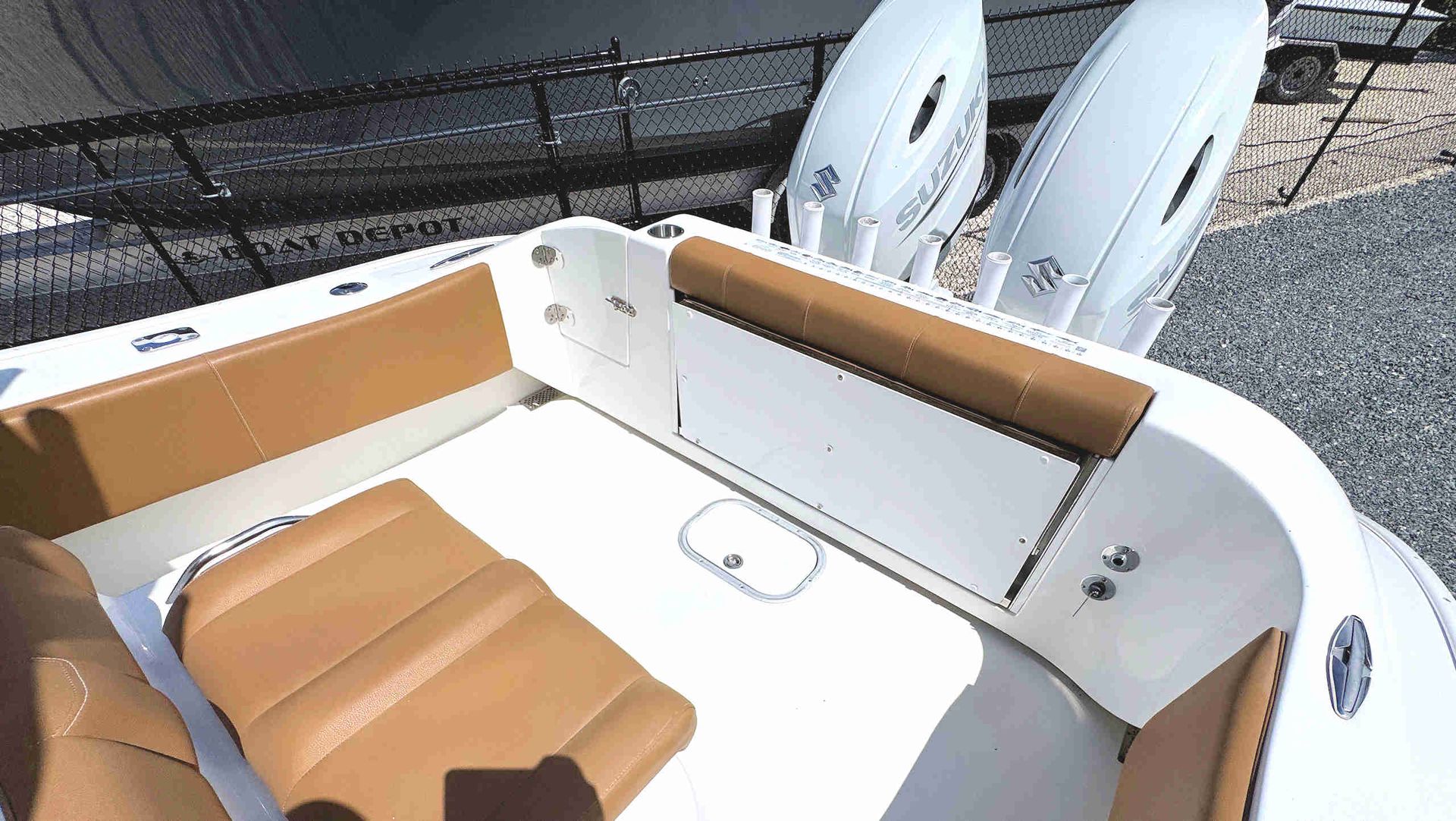 White boat deck with tan cushioned seats and two paddleboards at the stern