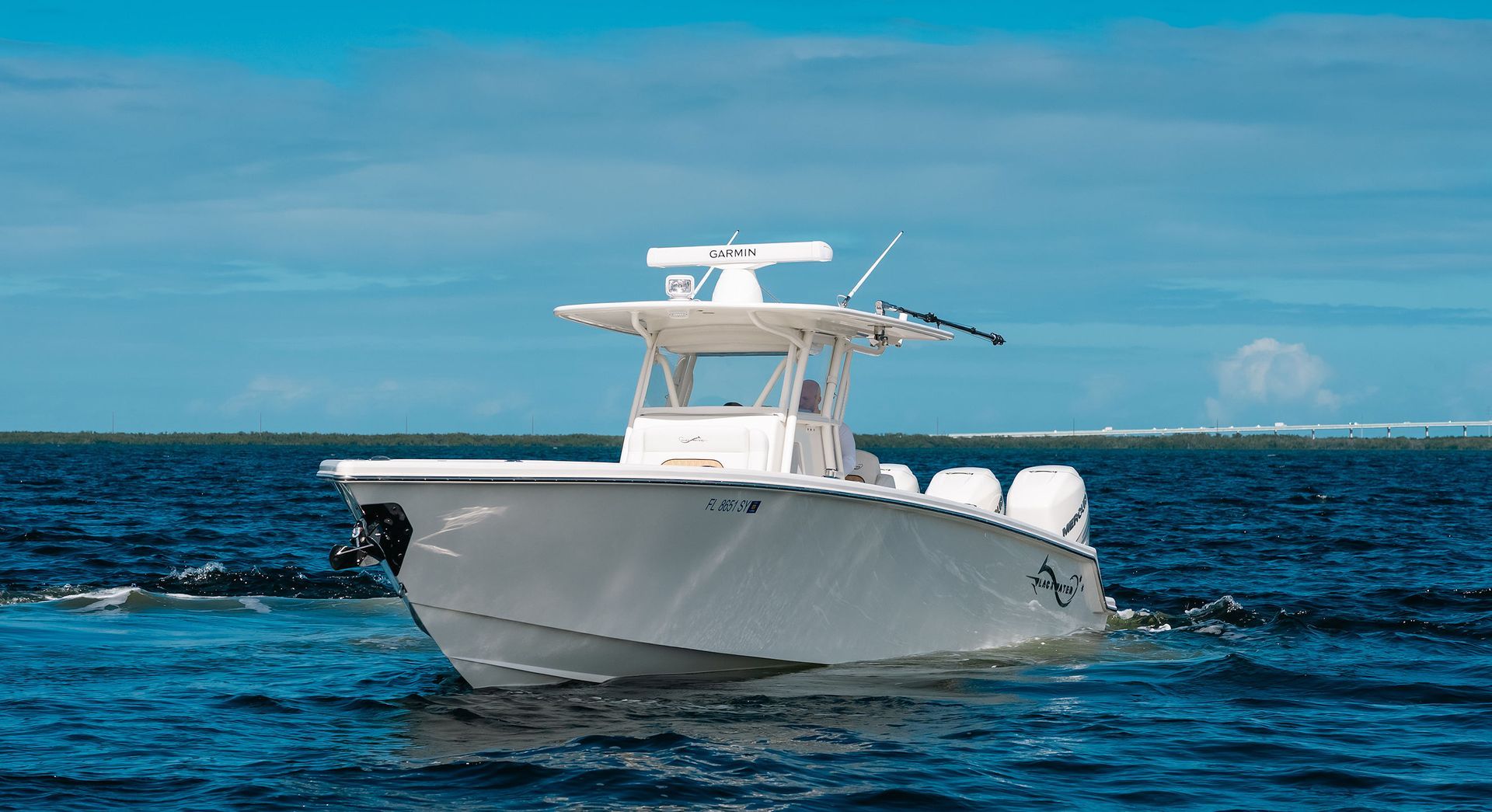 White motorboat cruising on blue ocean under a clear sky