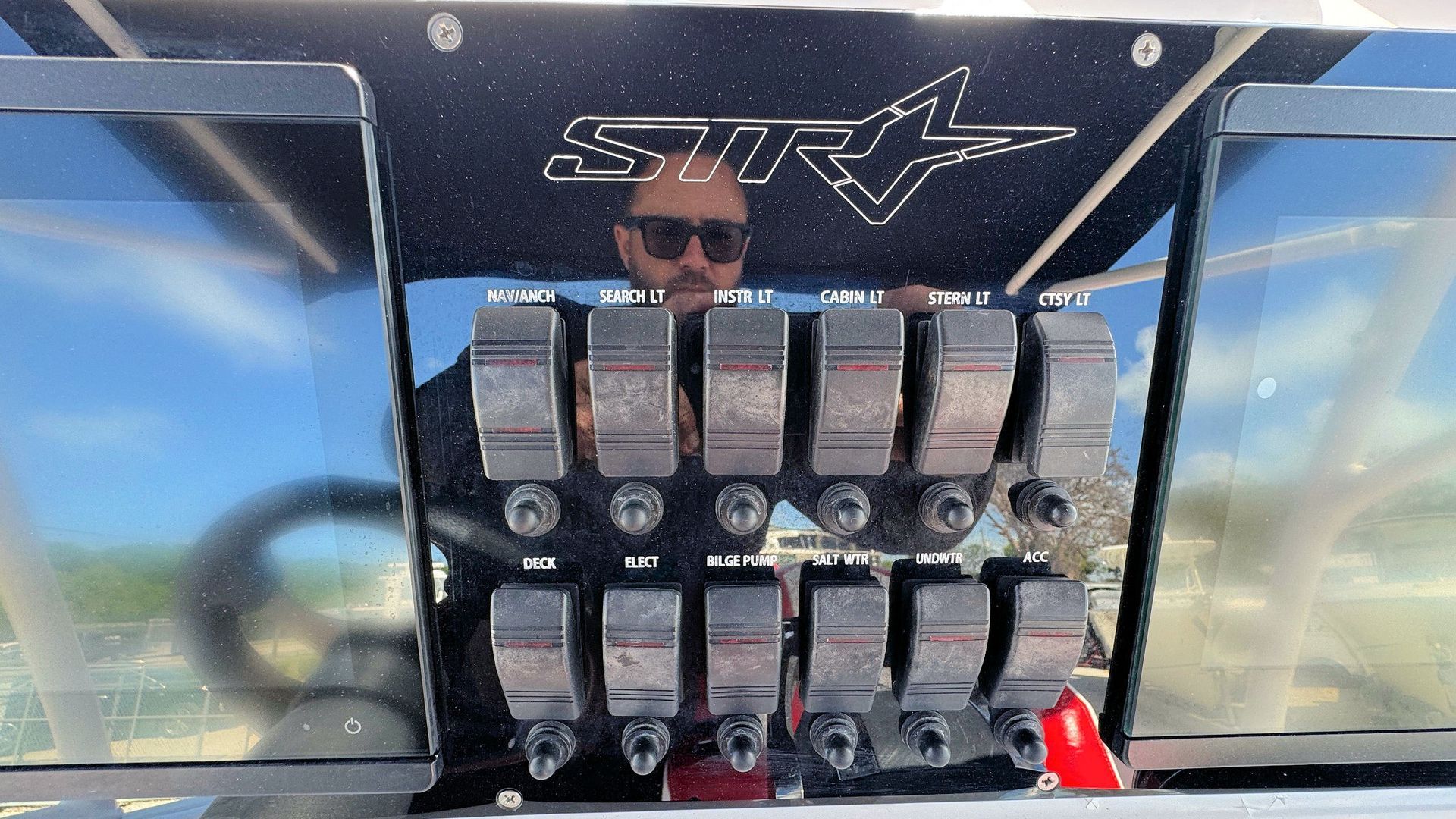 Row of metal toggle switches on a panel under a black canopy, with a star logo above.